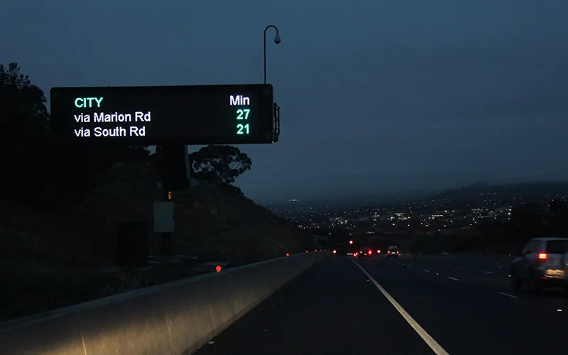 Variable Message Sign next to an expressway displaying travel times to the city via Marion Rd and South Rd