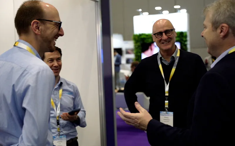 Paul Marwick (middle right), James Cox, and Jonathon Rossi talk with a hardware vendor (right) at Addinsight’s exhibition stand at ITS Australia Global Summit 2023.