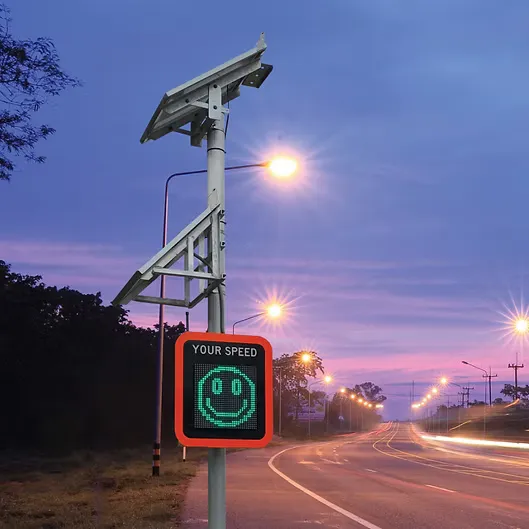 J1-LED speed advisory sign showing a smiley face, at night